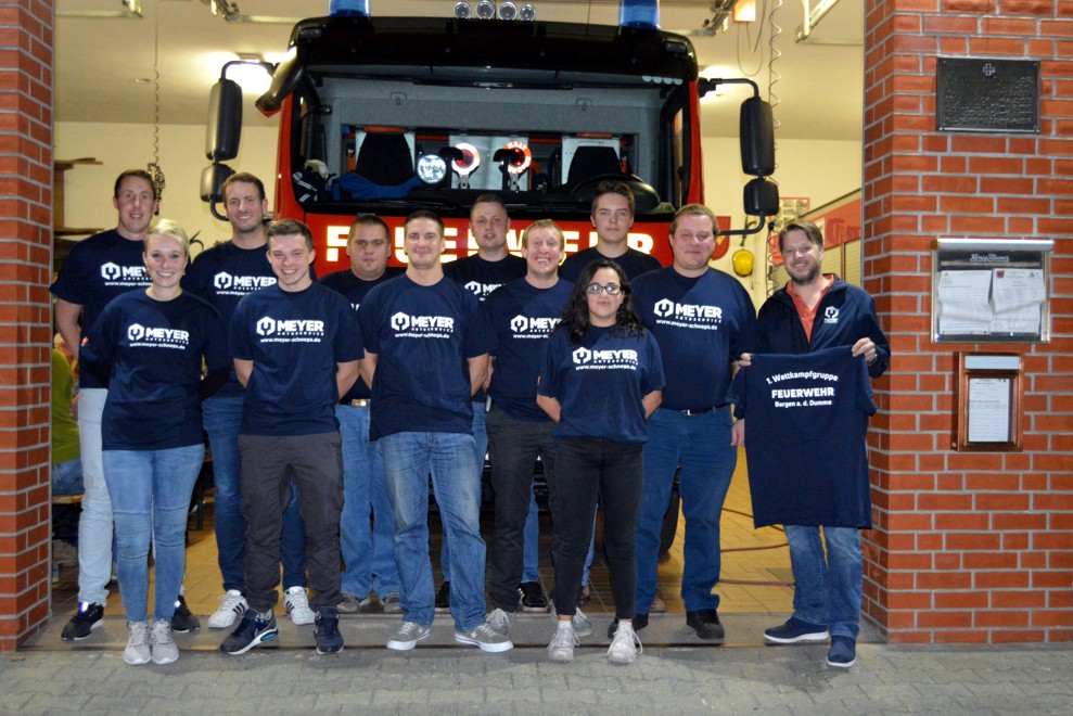 Nils Meyer überreicht der Wettkampfgruppe der FF Bergen/D. neue T-Shirts